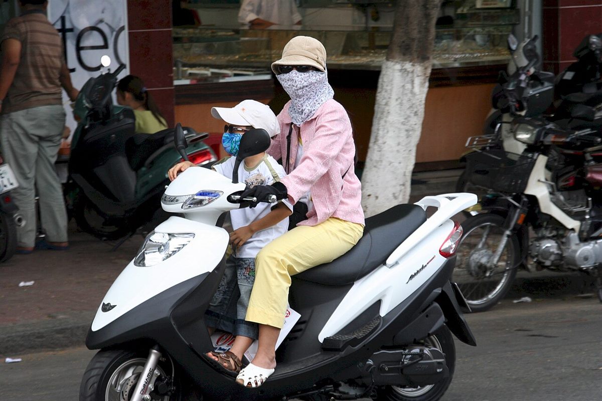 Người mẹ chở con nhỏ trên xe máy